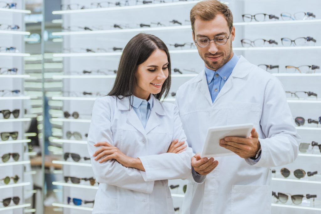 opticians, opticians in the eyeglass store, male and female optician, male and female optician in the eyeglass store