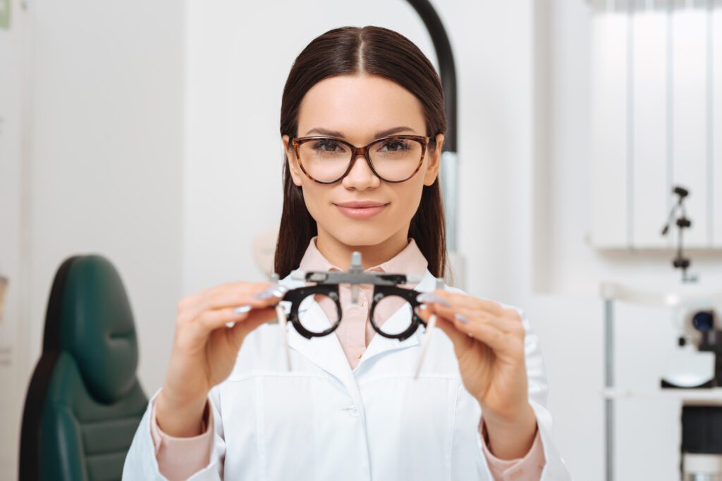 optometrist, female optometrist, female optometrist holding opthalmoscope